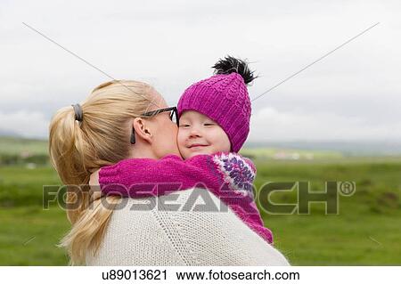 Mother hugging young daughter, outdoors View Large Photo Image Stock Image - Mother hugging young daughter, outdoors. Fotosearch
