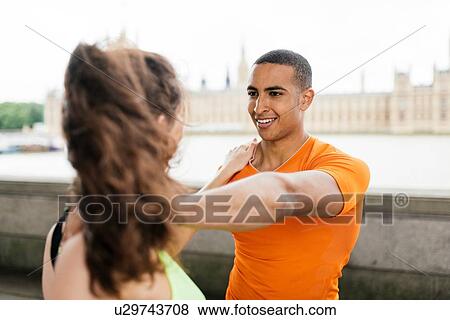 Over shoulder view of male and female runners warming up on riverside View Large Photo Image Stock Photo - Over shoulder view of male and female runners warming up on riverside. Fotosearch