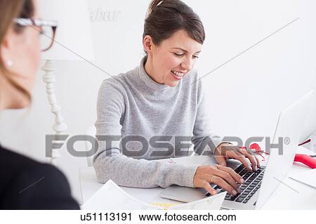 Over shoulder view of mature woman using laptop looking down smiling View Large Photo Image Stock Image - Over shoulder view of mature woman using laptop looking down smiling. Fotosearch