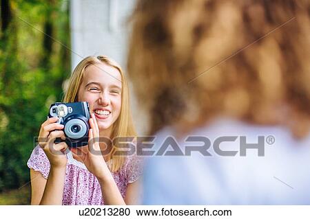 Over shoulder view of two tween girls photographing with instant camera View Large Photo Image Stock Image - Over shoulder view of two tween girls photographing with instant camera. Fotosearch