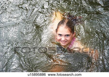 Stock Photograph - Overhead portrait of girl swimming in rural lake. Fotosearch
