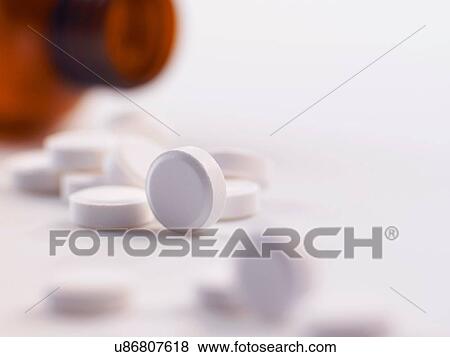 Pain killer pills spilling out of a bottle View Large Photo Image Stock Photo - Pain killer pills spilling out of a bottle. Fotosearch
