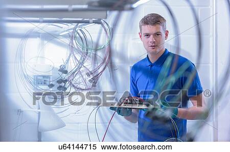 Stock Photography - Portrait of apprentice electronics worker in electronics factory,. Fotosearch