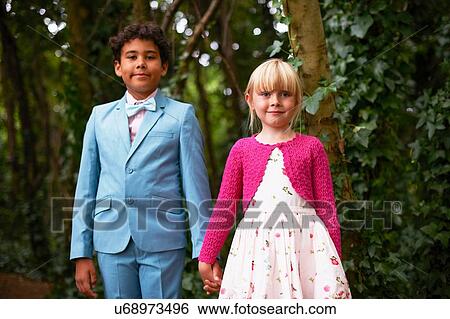 Portrait of boy and girl holding hands at garden birthday party View Large Photo Image Stock Photograph - Portrait of boy and girl holding hands at garden birthday party. Fotosearch