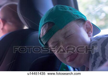 Portrait of boy wearing baseball cap pulling face in car View Large Photo Image Stock Photography - Portrait of boy wearing baseball cap pulling face in car. Fotosearch