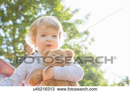 Portrait of cute female toddler hugging teddy bear on playground slide View Large Photo Image Stock Image - Portrait of cute female toddler hugging teddy bear on playground slide. Fotosearch