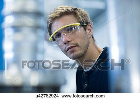 Picture - Portrait of factory engineer wearing protective eyeglasses. Fotosearch