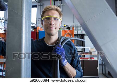 Picture - Portrait of factory technician with cabling. Fotosearch