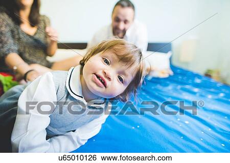 Portrait of female toddler with parents on bed View Large Photo Image Stock Photograph - Portrait of female toddler with parents on bed. Fotosearch