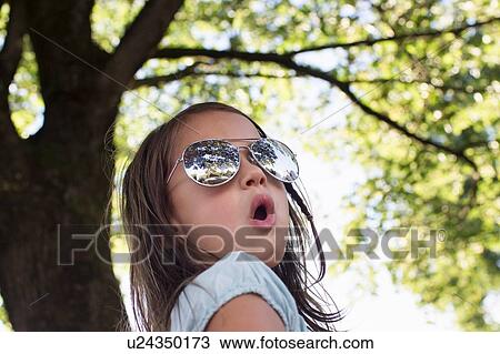 Portrait of girl wearing sunglasses in park View Large Photo Image Stock Image - Portrait of girl wearing sunglasses in park. Fotosearch