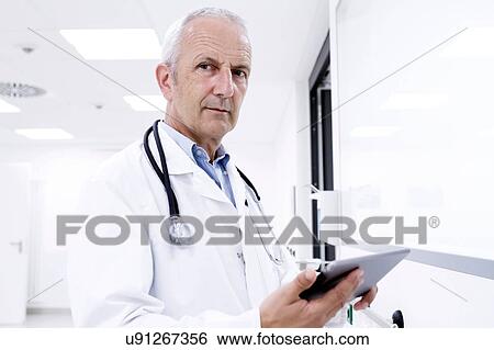Portrait of male doctor holding digital tablet View Large Photo Image Stock Photograph - Portrait of male doctor holding digital tablet. Fotosearch