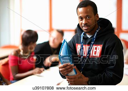 Portrait of male student holding file in front of class View Large Photo Image Stock Photo - Portrait of male student holding file in front of class. Fotosearch