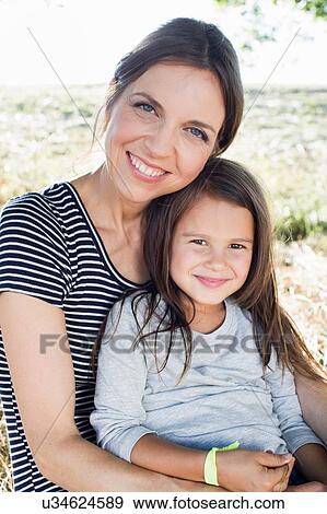 Portrait of mature woman and daughter sitting in park View Large Photo Image Stock Photo - Portrait of mature woman and daughter sitting in park. Fotosearch