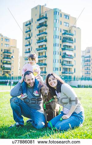 Portrait of mid adult couple with toddler daughter on shoulders in park View Large Photo Image Stock Image - Portrait of mid adult couple with toddler daughter on shoulders in park. Fotosearch