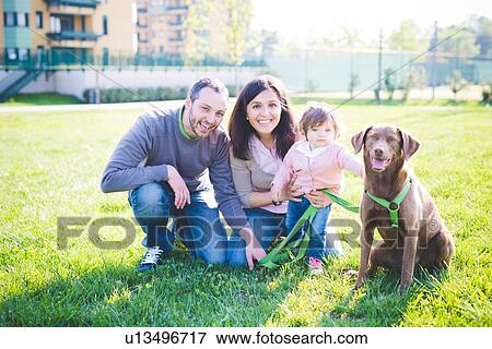 Portrait of mid adult couple with toddler daughter and dog in park View Large Photo Image Stock Photo - Portrait of mid adult couple with toddler daughter and dog in park. Fotosearch