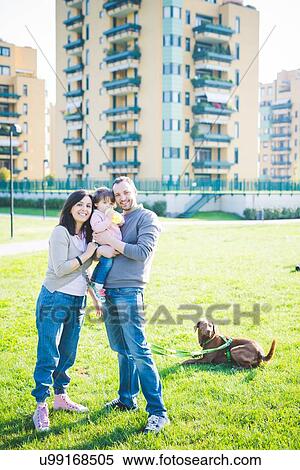 Portrait of mid adult couple with toddler daughter and dog in park View Large Photo Image Stock Photography - Portrait of mid adult couple with toddler daughter and dog in park. Fotosearch
