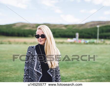 Portrait of mid adult long haired blond woman wearing sunglasses looking at camera View Large Photo Image Stock Photo - Portrait of mid adult long haired blond woman wearing sunglasses looking at camera. Fotosearch