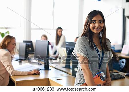 Portrait of smiling female student holding file in class View Large Photo Image Stock Image - Portrait of smiling female student holding file in class. Fotosearch