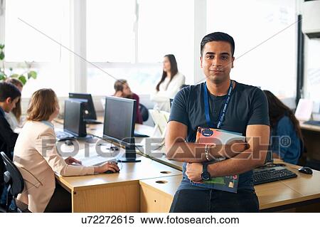 Portrait of smiling male student holding file in class View Large Photo Image Stock Photography - Portrait of smiling male student holding file in class. Fotosearch