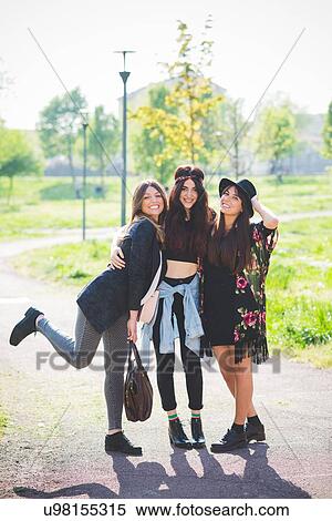 Stock Photography - Portrait of three stylish young female friends in park. Fotosearch