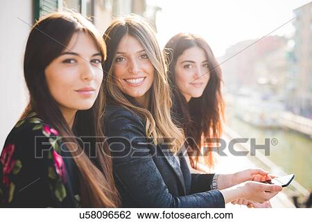 Portrait of three young female friends on waterfront balcony View Large Photo Image Stock Image - Portrait of three young female friends on waterfront balcony. Fotosearch