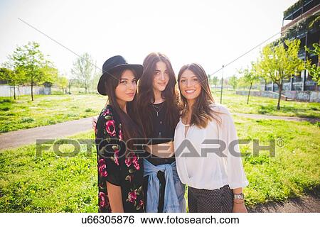 Portrait of three young female friends in park View Large Photo Image Stock Photograph - Portrait of three young female friends in park. Fotosearch