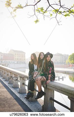 Portrait of three young women sitting on canal waterfront View Large Photo Image Stock Image - Portrait of three young women sitting on canal waterfront. Fotosearch