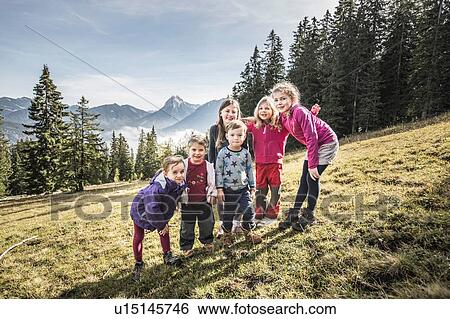 Stock Photograph - Portrait of two women and four children in field, Achenkirch, Austria. Fotosearch