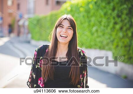 Portrait of young woman with long brown hair laughing View Large Photo Image Stock Photograph - Portrait of young woman with long brown hair laughing. Fotosearch