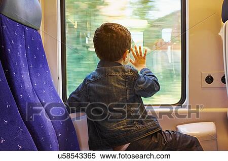 Rear view of boy with his hand against train carriage window View Large Photo Image Stock Photography - Rear view of boy with his hand against train carriage window. Fotosearch