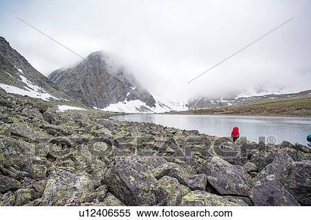 Rear view of male hiker looking out at lake, Ural mountains, Russia View Large Photo Image Stock Photography - Rear view of male hiker looking out at lake, Ural mountains, Russia. Fotosearch