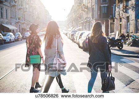 Rear view of three young women strolling over pedestrian crossing View Large Photo Image Stock Photograph - Rear view of three young women strolling over pedestrian crossing. Fotosearch