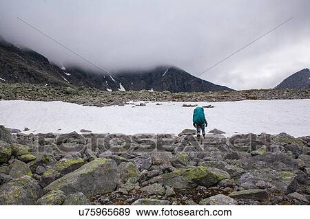 Rear view of young male hiker looking out at frozen lake, Ural mountains, Russia View Large Photo Image Stock Photo - Rear view of young male hiker looking out at frozen lake, Ural mountains, Russia. Fotosearch