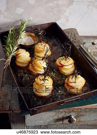 Stock Image - Roasted shaved potatoes with rosemary and salt. Fotosearch