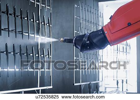 Stock Photography - Robot spray painting automotive parts in spray paint factory, close up. Fotosearch