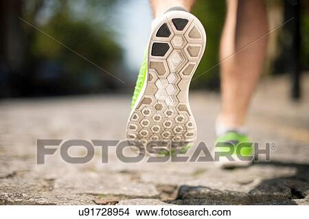 Picture - Runner jogging on cobbled street. Fotosearch
