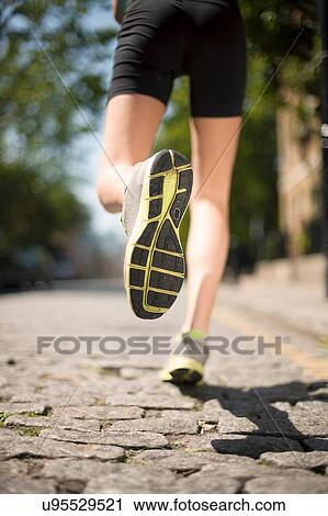 Runner jogging on cobbled street View Large Photo Image Stock Image - Runner jogging on cobbled street. Fotosearch