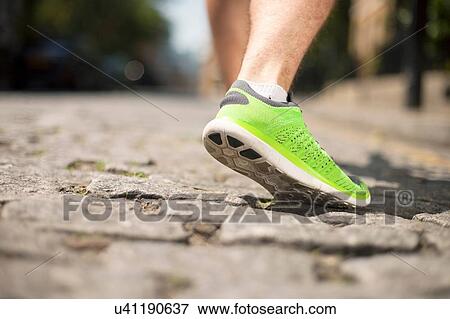 Stock Photo - Runner jogging on cobbled street. Fotosearch
