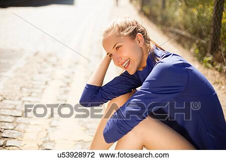 Stock Image - Runner resting on pavement. Fotosearch