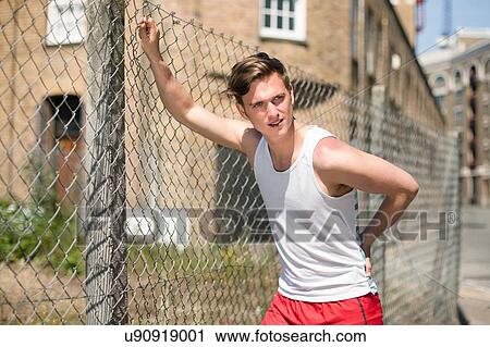 Runner stretching against wire fence, Wapping, London View Large Photo Image Stock Image - Runner stretching against wire fence, Wapping, London. Fotosearch