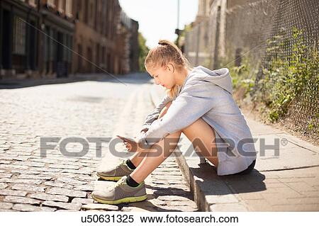 Runner using smartphone on pavement, Wapping, London View Large Photo Image Stock Photography - Runner using smartphone on pavement, Wapping, London. Fotosearch