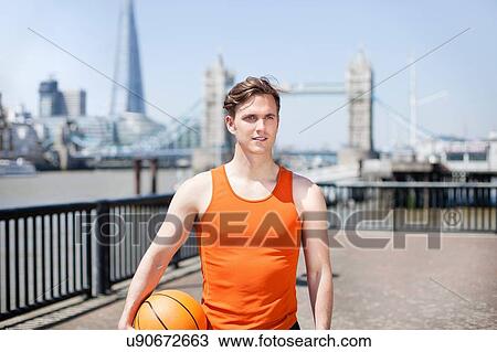 Stock Image - Runner with ball on riverfront, Wapping, London. Fotosearch