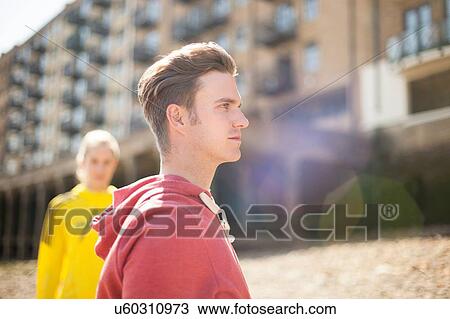 Stock Image - Runners standing by building block, Wapping, London. Fotosearch