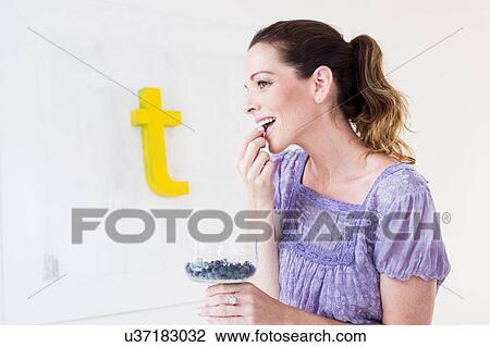 Side view of mature woman holding glass bowl of blueberries, eating View Large Photo Image Stock Image - Side view of mature woman holding glass bowl of blueberries, eating. Fotosearch