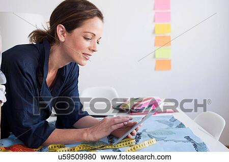 Side view of mature women resting on elbows using digital tablet View Large Photo Image Stock Image - Side view of mature women resting on elbows using digital tablet. Fotosearch