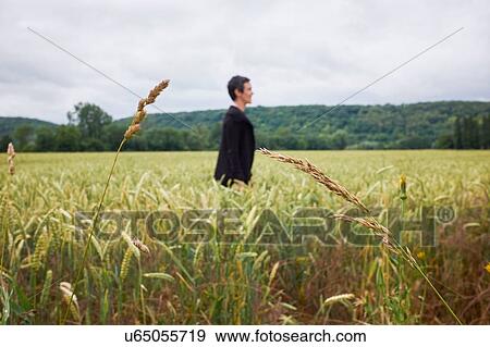 Side view of woman standing in cornfield View Large Photo Image Stock Photo - Side view of woman standing in cornfield. Fotosearch