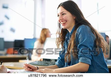 Smiling female student having classroom tutorial View Large Photo Image Stock Photograph - Smiling female student having classroom tutorial. Fotosearch