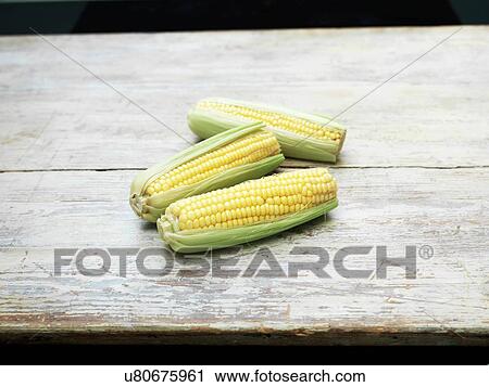 Still life of three fresh corn cobs on wooden table View Large Photo Image Stock Image - Still life of three fresh corn cobs on wooden table. Fotosearch