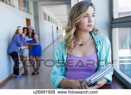 Student looking out window, friends gossiping in background View Large Photo Image Stock Photo - Student looking out window, friends gossiping in background. Fotosearch