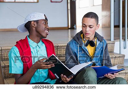 Students on steps, reading textbook View Large Photo Image Stock Photograph - Students on steps, reading textbook. Fotosearch